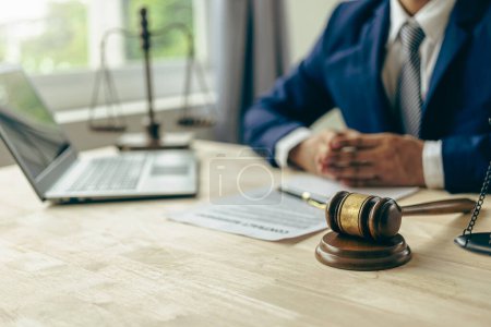 Photo for Male lawyer working with judge's gavel and golden scales in law office Close-up pictures - Royalty Free Image