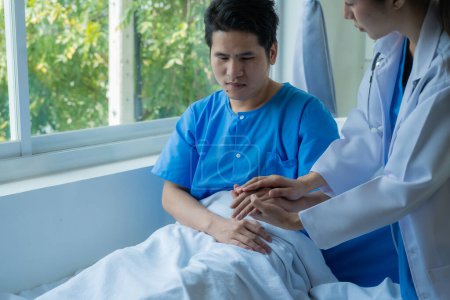 Téléchargez les photos : Patient asiatique de sexe masculin couché sur le lit avec une équipe de médecins fournissant consultation et soulagement à côté du concept de santé médicale. - en image libre de droit