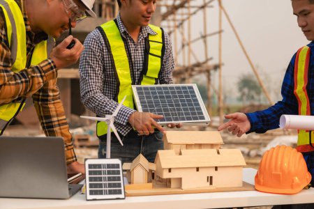 Téléchargez les photos : Les travailleurs et les ingénieurs parlent d'installer un système de panneaux solaires. Technicien de panneaux solaires installe des panneaux solaires sur le toit. concepts d'énergies alternatives - en image libre de droit