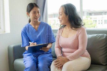 Photo for Asian female doctor talks to patient with smile to encourage patient at hospital An elderly Asian woman visits a doctor at a hospital office. Talk about the results of the health examination - Royalty Free Image