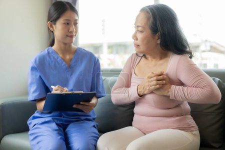 Photo for Asian female doctor talks to patient with smile to encourage patient at hospital An elderly Asian woman visits a doctor at a hospital office. Talk about the results of the health examination - Royalty Free Image