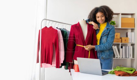 Téléchargez les photos : Les filles afro-américaines offrent et vendent des vêtements en ligne via le streaming en direct, les achats sur Internet, certains magasins de vêtements élégants, les startups, les petites entreprises, les PME, les femmes propriétaires d'entreprises africaines. - en image libre de droit