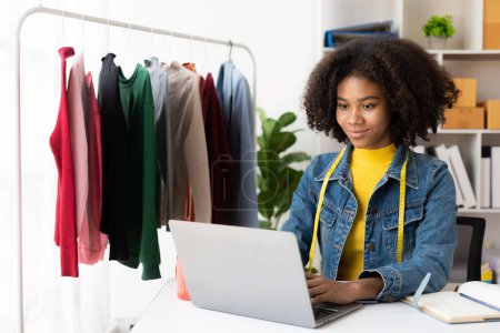Photo for African American girls offer and sell clothes online via live streaming, internet shopping, select stylish clothing stores, startups, small businesses, SMEs, African female business owners. - Royalty Free Image