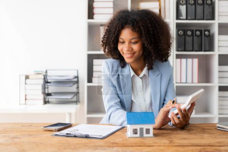 Téléchargez les photos : Afro-Américaine tient stylo pour lire le document d'accord pour signer un prêt foncier avec un agent immobilier ou un caissier bancaire, concept d'assurance - en image libre de droit