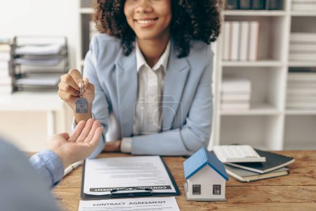 Photo for African American girl holds pen to read agreement document to sign land loan with real estate agent or bank teller, insurance concept - Royalty Free Image