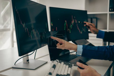 Photo for Stock trader looking at stock market chart on screen, analyzing investment strategy, finance working with monitor screen with stock charts and indicators, people working hard to make risk decisions - Royalty Free Image