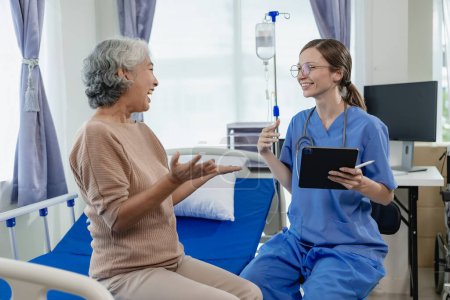 Photo for Female doctor with clipboard talking with elderly female patient at hospital Senior woman or doctor with digital tablet Consult or plan treatment to treat medical professionals with female patients. - Royalty Free Image