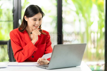 Photo for Analytical research concept, Asian woman using calculator and laptop to do finance, mathematics on office table, taxes, reports, accounting, statistics. - Royalty Free Image