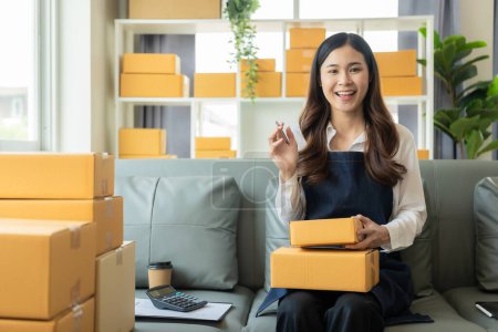 Photo for Small business entrepreneur or freelance Asian woman working with parcel boxes Young successful woman with packaging boxes, online marketing and her delivery, SME business concept - Royalty Free Image