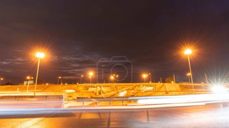 Photo for Time movement of fast night driving in a big city from the car window in front to the road with light lines from vehicles and street lights. - Royalty Free Image