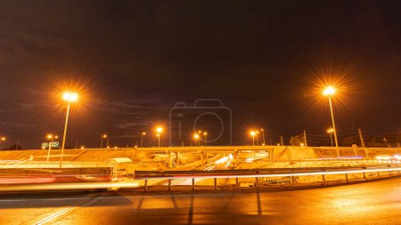 Foto de Movimiento del tiempo de conducción nocturna rápida en una gran ciudad desde la ventana del coche en frente de la carretera con líneas de luz de los vehículos y luces de la calle. - Imagen libre de derechos
