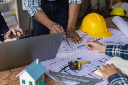 Photo for Concept architect, engineer, team holding pen, pointing architect, equipment on table with blueprints, ready to discuss home design in office. - Royalty Free Image