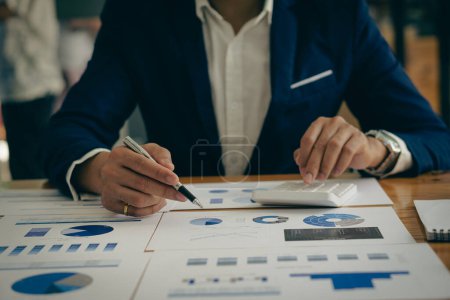 Photo for Businessman pointing at business document for chart and graph data analysis and accounting business woman holding pen and pointing at financial documents to analyze profit concept - Royalty Free Image