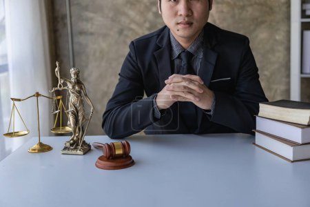 Photo for Asian male lawyer working in law office with hammer and scale and laptop, contract concept legal proceedings - Royalty Free Image