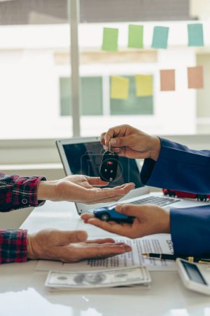 Photo for Car rental service concept Close up view of hands of representative handing car keys to customer after signing lease contract, document contract, vehicle. Sales agreement vertical picture - Royalty Free Image