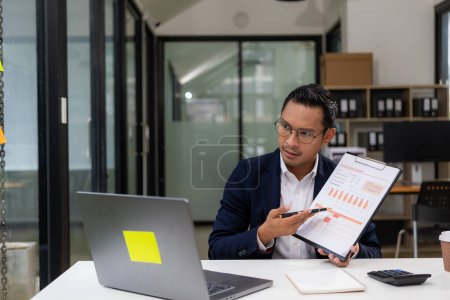 Photo for Asian businessman working at a desk business financial technology financial documents and business accounting With laptop and documents on desk, financial planning concept in office - Royalty Free Image