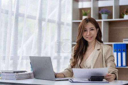 Téléchargez les photos : Femme freelance travaillant à l'aide d'un ordinateur portable effectuant une analyse comptable financière pour signaler l'information sur les investissements des entreprises - en image libre de droit