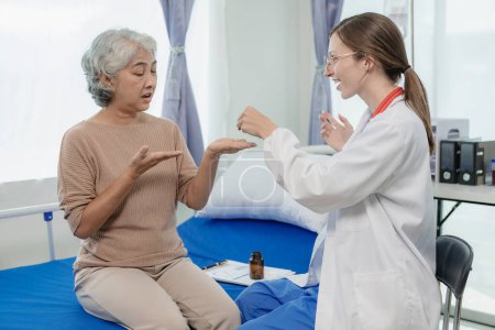 Téléchargez les photos : Une femme médecin parle à une patiente âgée en regardant les résultats de ses tests. Une patiente consulte un médecin féminin au sujet du traitement et des conseils de santé. - en image libre de droit