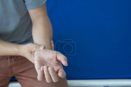Photo for Man has wrist pain from using smartphone or computer for a long time, arthritis, ergonomics, carpal tunnel syndrome or office syndrome. Close-up view - Royalty Free Image