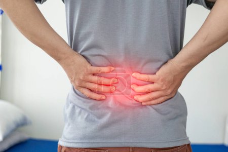 Photo for Office Syndrome: Man touching lower back at pain point with red notes, back and waist pain. Asian man touching back with musculoskeletal pain. Close-up photo - Royalty Free Image