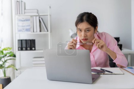 Photo for Annual summary report, laptop and paper placed at desk, Asian woman working online and planning financial data with laptop and succeeding with excited and happy face - Royalty Free Image