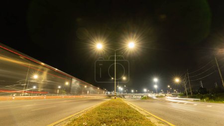 Téléchargez les photos : Lumière de vitesse dynamique abstraite longue exposition dans la ville avec de belles lumières multicolores, paillettes modernes dans la ville de nuit sur la route, vue arrière. Course sur le terrain - en image libre de droit