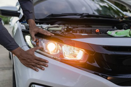 Photo for Car mechanic's hands holding car headlights, auto parts concept Car mechanic changes damaged car bulbs and inserts new bulbs under engine maintenance concept. - Royalty Free Image