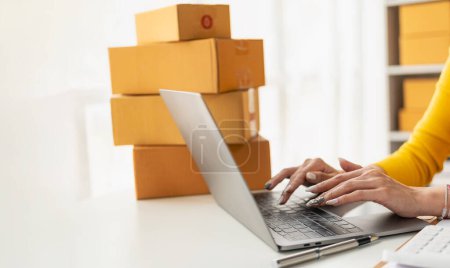 Der Verkäufer verpackt das Paket hinter der Versandbox. Vorbereitung von Paketen für das E-Commerce-Lieferservice-Konzept für KMU. Nahaufnahme.