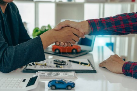 Photo for Car business, car sales, deals, gestures and concepts of close-up dealer people giving keys to new owner and shaking hands in office at table, close-up photo - Royalty Free Image