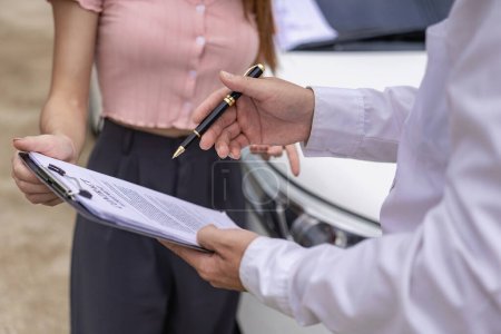 Photo for Car claim process Insurance agent after car accident writes on clipboard while inspecting car after accident claim is evaluated and processed Close-up pictures - Royalty Free Image