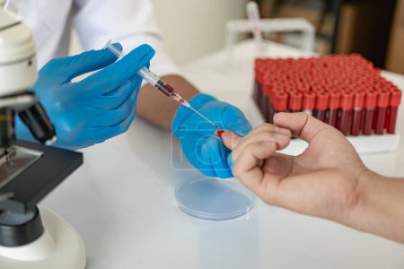 Téléchargez les photos : Le médecin de l'hôpital tient un test des vaisseaux sanguins en laboratoire avec un échantillon de sang de l'étagère avec un analyseur en laboratoire - en image libre de droit