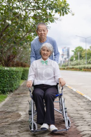 Foto de Feliz pareja de ancianos asiáticos caminando juntos por un sendero de bosque tropical Hombre y mujer ancianos jubilados divirtiéndose y disfrutando de actividades de viaje al aire libre. Imagen vertical - Imagen libre de derechos