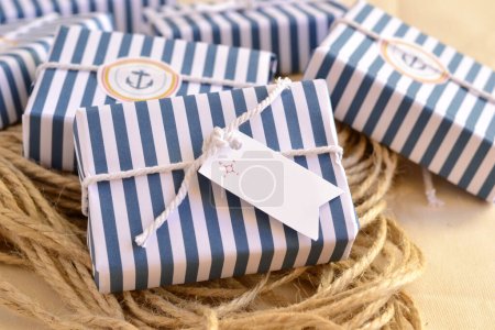 Cadeaux invités de savon de décoration de style nautique, enveloppé dans du papier à rayures blanches bleues, ruban de coton, étiquette personnalisée, fond de corde de marin, souvenir original de fête de plage d'été