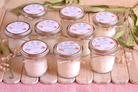 Wedding favors glass jar custom candles for party guests on favor wood table, personalized label text with bride groom names