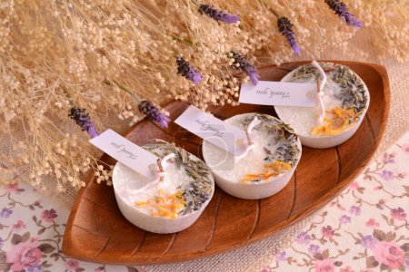Hochzeit begünstigt botanische Kerzen Lavendel maßgeschneiderte handgefertigte Gastgeschenke auf dem Tisch mit Holzhintergrund, personalisierte Party-Souvenirs, originelles kleines Geschenk