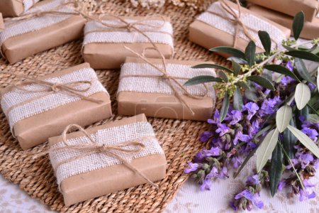 Wedding favors purple natural color decoration brown craft gift box with white burlap and jute ribbon, wicker, sage and olive leaves background  handmade soap packaging
