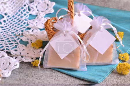 Wedding favor diy handmade soap in organza bag on blue background, baby boy shower custom souvenir