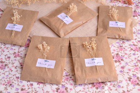 Wedding favors packaging in craft bags with custom label and dry flowers decoration, ecological party diy handmade souvenirs in natural color