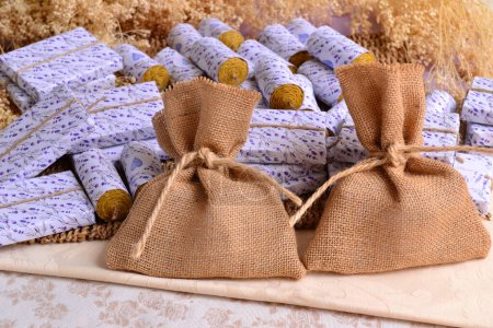 Wedding favours jute bags with guest gifts beeswax ecological candles and handmade soaps natural souvenirs, fall autumn or summer party celebration, rustic lavender style decoration brown purple color