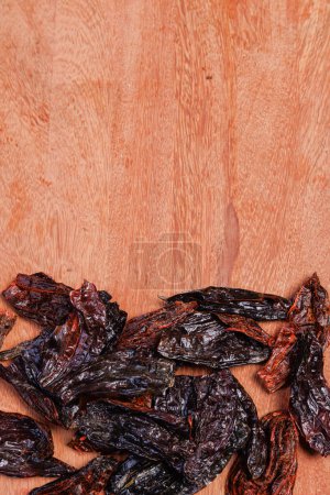 Photo for Background of a kitchen table with a typical chile from Peru, the aji panca. A dried chili. - Royalty Free Image