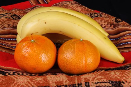Photo for Fruit, bananas and tangerines from the cultivated fields of Peru together with a typical backpack made with Andean fabrics from the highlands of Peru - Royalty Free Image