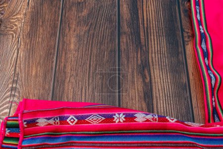 Photo for Wooden table with fabrics made manually by people who live in the Peruvian mountains from pre-Hispanic times with embroidery and bright colors - Royalty Free Image