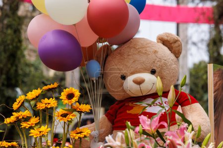 Photo for Teddy bear with balloons and flowers of many colors - Royalty Free Image