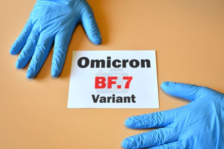 Photo for The hands of doctor in blue gloves with white paper and text "Omicron BF.7 Variant". Concept for the new variant of SARS-CoV-2 Omicron BF.7 Covid-19 New Variants. - Royalty Free Image