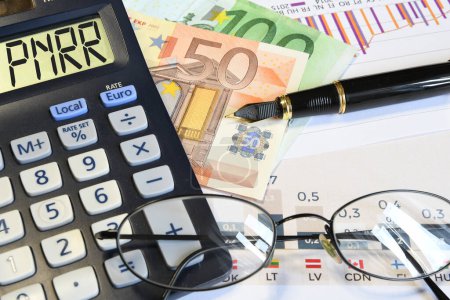 Taschenrechner mit "PNRR" -Zeichen sowie Finanzgrafiken, Euro-Banknoten, Brille und Stift.