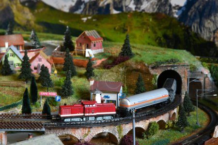 Photo for Miniature railway model with model freight train that exit from a tunnel on a mountains ambientation. Toy Train - Royalty Free Image