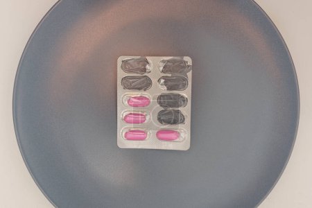 Foto de Aspectos esenciales del tratamiento farmacológico: Blíster de píldora parcialmente lleno con geles suaves rosados - Imagen libre de derechos