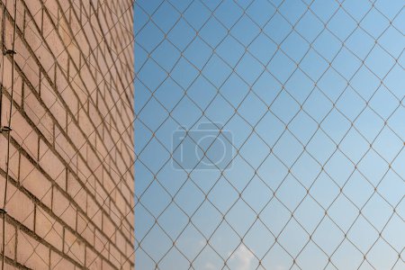 A protective mesh installed on the balcony of a brick building, ensuring accident prevention for children and pets, set against a clear blue sky backdrop