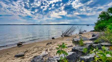 Grand Traverse Bay, Michigan shore on a partly cloudy day. View from the shore.