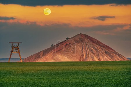 Photo for A view of an overburden heap in saxony-anhalt with a winding tower at moonrise - Royalty Free Image
